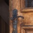 Alte Holztür mit schmiedeeisernem Beschlag steht einen Spalt offen – Sinnbild der Auflassung beim Grundstückskauf
